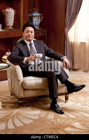 Reife Geschäftsmann Kaffeetrinken in einem luxuriösen Zimmer Stockfoto