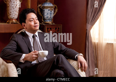 Reife Geschäftsmann Kaffeetrinken in einem luxuriösen Zimmer Stockfoto