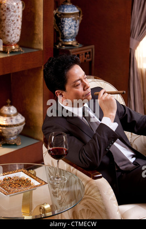 Reife Geschäftsmann Zigarren und Wein in einem luxuriösen Zimmer Stockfoto