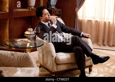 Reife Geschäftsmann Zigarren und Wein in einem luxuriösen Zimmer Stockfoto