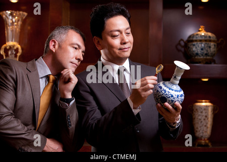 Reife Geschäftsleute bewundern, eine antike chinesische vase Stockfoto