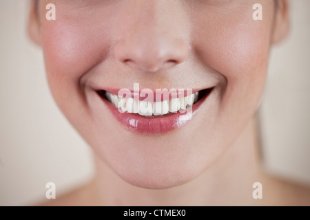 Nahaufnahme einer jungen Frau lächelnd, front Ansicht Stockfoto