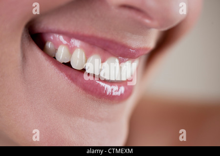 Nahaufnahme einer jungen Frau lächelnd, seitliche Ansicht Stockfoto