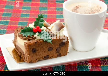 Buchette de Noel mit ein Milchkaffee. Die klassischen Buche de Noel ist die Französisch Weihnachten Kuchen in der Form eines Yule log. Stockfoto