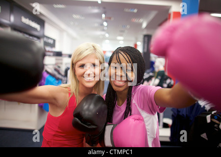 Zwei junge Frauen tragen Boxhandschuhe und schaut in die Kamera, Pietermaritzburg, KwaZulu-Natal, Südafrika Stockfoto