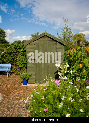 Grüner Holzschuppen auf einem York-Schlot, mit einem Blumenbeet im Vordergrund. VEREINIGTES KÖNIGREICH. Stockfoto