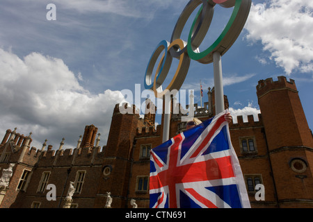 London-Lady steht für ein Erinnerungsfoto auf die Olympischen Ringe, die am Eingang des König Heinrich der achtes Hampton Court Palace am ersten Tag des Wettbewerbs der Straßenrennen der Olympischen Spiele London 2012 250 km Mens stehen. Ausgehend vom Zentrum von London und berühmten Wahrzeichen der Hauptstadt vor der Überschrift heraus in ländlichen England an den zermürbenden Box Hill in der Grafschaft Surrey. Lokalen Südwest Londoner säumten die Strecke, in der Hoffnung auf britische Favorit Mark Cavendish gewinnt Team GB erste Medaille aber schließlich enttäuscht wenn Kasachstans Alexandre Vinokourov schließlich Gold gewann. Stockfoto