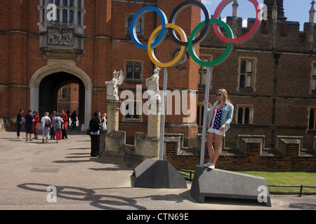 Amerikanerin steht für ein Erinnerungsfoto auf die Olympischen Ringe, die am Eingang des König Heinrich der achtes Hampton Court Palace am ersten Tag des Wettbewerbs der Straßenrennen der Olympischen Spiele London 2012 250 km Mens stehen. Ausgehend vom Zentrum von London und berühmten Wahrzeichen der Hauptstadt vor der Überschrift heraus in ländlichen England an den zermürbenden Box Hill in der Grafschaft Surrey. Lokalen Südwest Londoner säumten die Strecke, in der Hoffnung auf britische Favorit Mark Cavendish gewinnt Team GB erste Medaille aber schließlich enttäuscht wenn Kasachstans Alexandre Vinokourov schließlich Gold gewann. Stockfoto