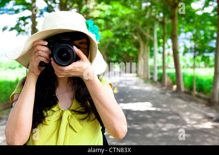 Junge Reisende nehmen Foto in den grünen Wald Stockfoto