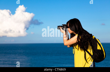 Junge Frau nehmen Foto mit Cloud-Hintergrund Stockfoto