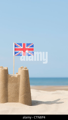 Union Jack-Flagge in eine Sandburg am Strand. Brunnen neben das Meer. Norfolk, England Stockfoto