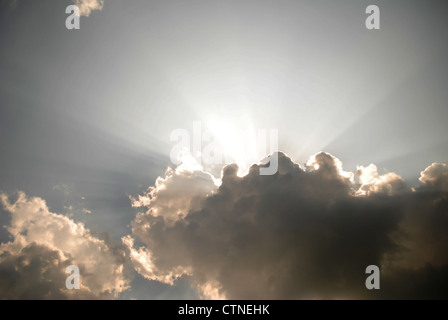 Strahlen der Sonne spähen aus hinter einigen Wolken Stockfoto