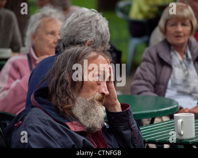 Ein Mann sitzt mit einer Tasse Tee im Pavilion Gardens, Brighton. Stockfoto
