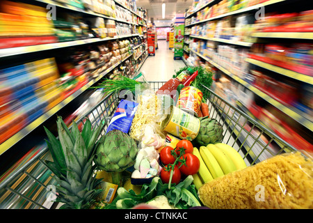 Essen Halle, voller Einkaufswagen wird durch einen Flur mit mehreren Nahrungsmitteln geschoben. Grosser Supermarkt, Self-Service. Stockfoto