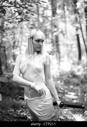 Fantasie blonde Frau mit Schwert im Wald Stockfoto