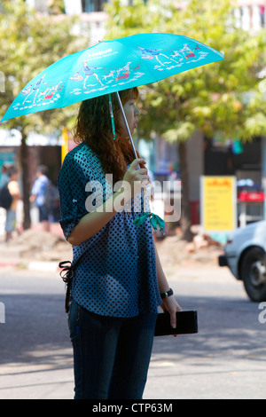 Burmesische Frau zu Fuß im Schatten eines Sonnenschirms in Yangon (Rangoon), Myanmar (Burma). Stockfoto