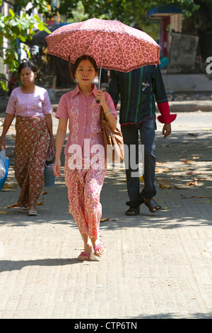 Burmesische Frau zu Fuß im Schatten eines Sonnenschirms in Yangon (Rangoon), Myanmar (Burma). Stockfoto