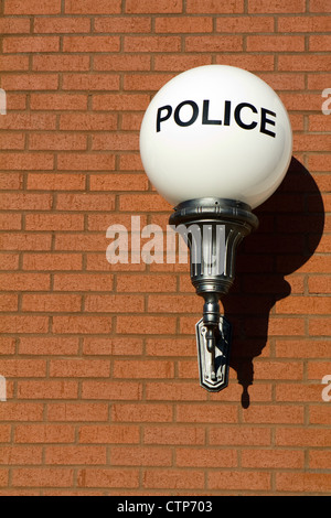 Alten altmodische Vintage Polizei Zeichen auf einem Globus Licht hängt an eine Mauer außerhalb einer Retro-gestaltete Stadt-Polizei-Station. Stockfoto