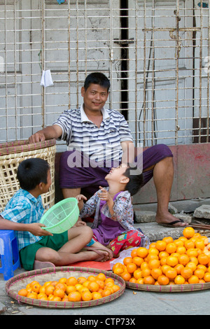 Burmesische Vater und Söhne Orangen auf die Strasse (Rangoon) Yangon, Myanmar (Burma) zu verkaufen. Stockfoto