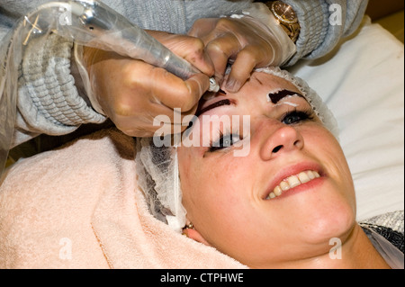 junge Frau in der Augenbrauen und Wimpern tätowieren Beauty-Behandlung in einem salon Stockfoto