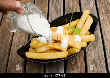 frisch gebratene Kartoffeln in schwarze Platte über alten Holztisch Stockfoto