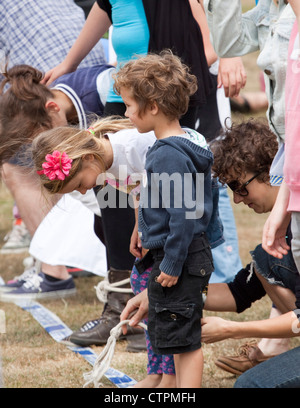 Bei einer Familie Spaß Tag Erwachsene und Kinder machen Sie sich bereit für ein drei Beinen Rennen. Stockfoto