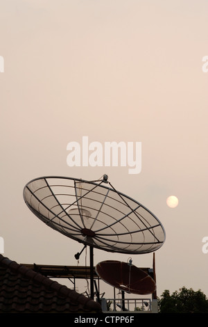 großer TV-Satellitenschüssel dominiert die Skyline der Jakarta in der Abenddämmerung Stockfoto