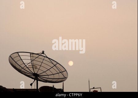 großer TV-Satellitenschüssel dominiert die Skyline der Jakarta in der Abenddämmerung Stockfoto