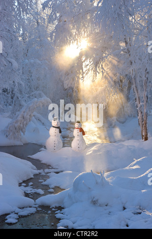 Schneemann paar stehen nächsten Stream Sonnenstrahlen durchschimmern Nebel hoar Milchglas Bäume im Hintergrund Russisch Buchse Springs Park Stockfoto