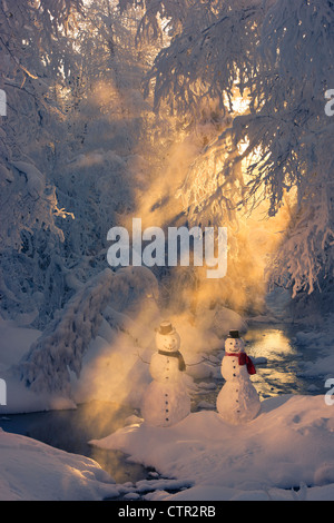 Schneemann paar stehen nächsten Stream Sonnenstrahlen durchschimmern Nebel hoar Milchglas Bäume im Hintergrund Russisch Buchse Springs Park Stockfoto