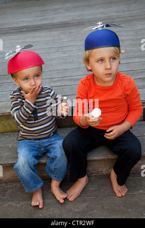 Zwei Brüder sind auf einer Stufe essen Eiscreme-Kegel. Stockfoto