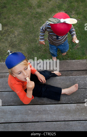 Zwei Brüder sind auf einer Stufe essen Eiscreme-Kegel. Stockfoto
