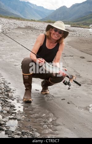 Reife Frau hocken Angelrute zeigt Dolly Varden Char gefangen in Canning River Brooks Range Arctic National Wildlife Stockfoto