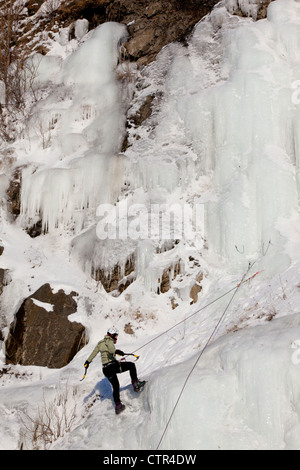 Weibliche Eis Kletterer Abseilen auf einer Eiswand neben den Seward Highway, Yunan Alaska, Winter Stockfoto