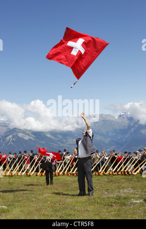 Fahnenschwinger & Alphornbläser beteiligen sich an der Morceaux d'ensemble Cor des Alpes Festival von Nendaz, Wallis, Schweiz Stockfoto