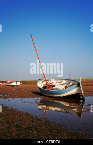 Ein Fischerboot inshore Klinker gebaut gestrandet bei Ebbe am Burnham Overy Staithe, Norfolk, England, Vereinigtes Königreich. Stockfoto