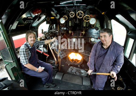 Trainieren Sie Fahrer und Feuerwehrmann in der Kabine der Southern Railway Dampflokomotive "West Country" Klasse Pacific 4-6-2 Anzahl 34028 "Eddystone" auf der erhaltenen Swanage Railway in Dorset UK Stockfoto