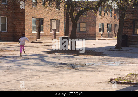 Ein junges Mädchen läuft durch den Verurteilten Ida B. Wells Wohnprojekt in Chicago am 24. April 2002. Stockfoto