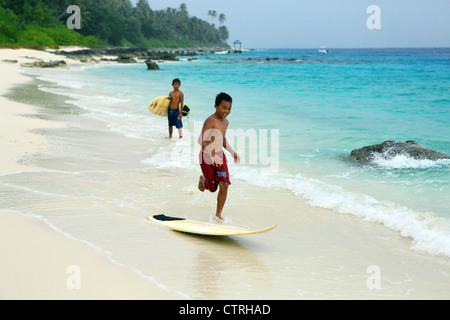 Indonesischen Jungen Skim-Board Surfen am Strand von Asu Insel in Nord-Sumatra. Stockfoto