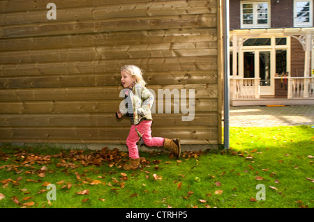 Kleines Mädchen läuft in ihrem Garten Stockfoto
