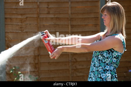 Frau mit einem trockenen Pulver-Feuerlöscher Stockfoto