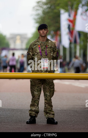 Ein Soldat der britischen Armee Stand bewachen den Eingang zum Volleyball Veranstaltungsort im Zentrum von London neben dem IOC Ringe Logo am 4. Tag der Olympischen Spiele 2012 in London. Weitere 1.200 Soldaten werden zum Sichern der Olympischen Spiele 2012 in London nach dem Scheitern von Sicherheit Fremdfirma G4S bieten genügend private Wachen eingesetzt. Das zusätzliche Personal wurden in inmitten weiter Ängste, die die private Sicherheit des Auftragnehmers Handhabung der £284m Vertrag bleibt ein Risiko für die Spiele erstellt. Stockfoto