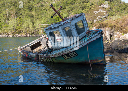 Ein verfallenes altes Fischerboot verzichtet auf ein Loch auf der Isle Of Skye, Schottland Stockfoto