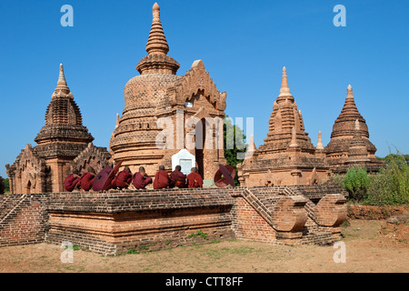 Myanmar, Burma. Bagan. Junge Novizin Mönche beten vor einem Tempel. Stockfoto