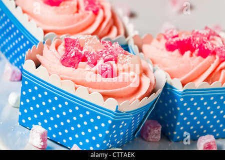 leckere rosa Muffins in blauen und weißen Feldern, dekoriert mit Lokum Stockfoto