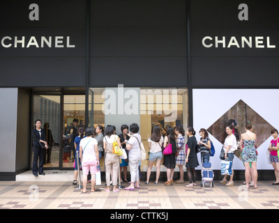 Warteschlange der Käufer warten geduldig in der Linie außerhalb einer Chanel shop in Hongkong eingeben Stockfoto