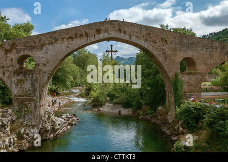 Römische mittelalterliche Brücke über den Fluss Sella im Cangas de Onís Rat mit dem Victoria Cross hängende, Symbol des Fürstentums Asturien, Spanien. Stockfoto