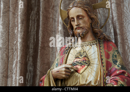 Das Christentum. Eine Statue von Jesus Christus. In dieser traditionellen katholischen Darstellung zeigt seine verletzte Hand auf symbolische Sacré Coeur. Stockfoto
