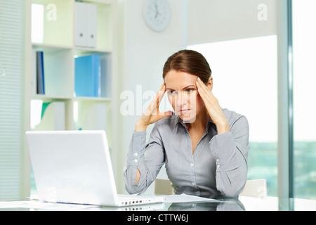 Business-Frau, die unter Kopfschmerzen leiden Stockfoto