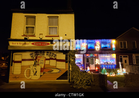 Über die obersten und klebrigen Weihnachtsdekorationen auf ein Wohnhaus neben einem Café in West Thurrock, Essex. Stockfoto